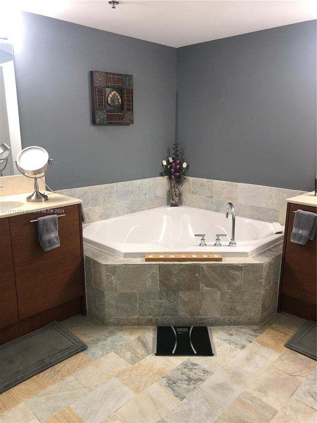 bathroom featuring vanity and tiled bath