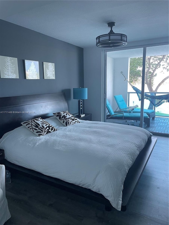 bedroom featuring access to exterior and hardwood / wood-style flooring