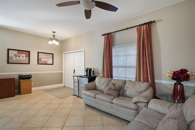 living room with ceiling fan with notable chandelier and light tile patterned floors