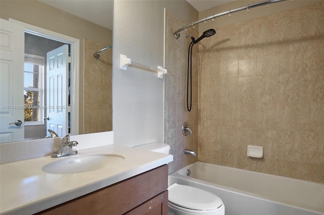 full bathroom with tiled shower / bath, vanity, and toilet