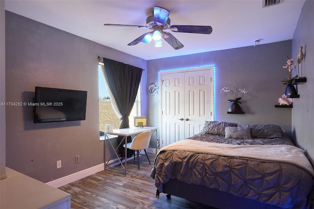 bedroom with ceiling fan, wood-type flooring, and a closet