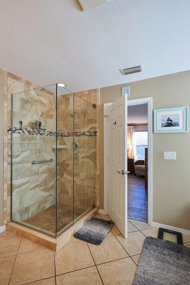 bathroom featuring tile patterned flooring, a textured ceiling, and walk in shower