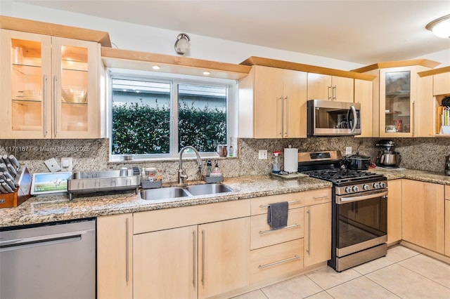 kitchen featuring light tile patterned flooring, appliances with stainless steel finishes, light brown cabinetry, and sink