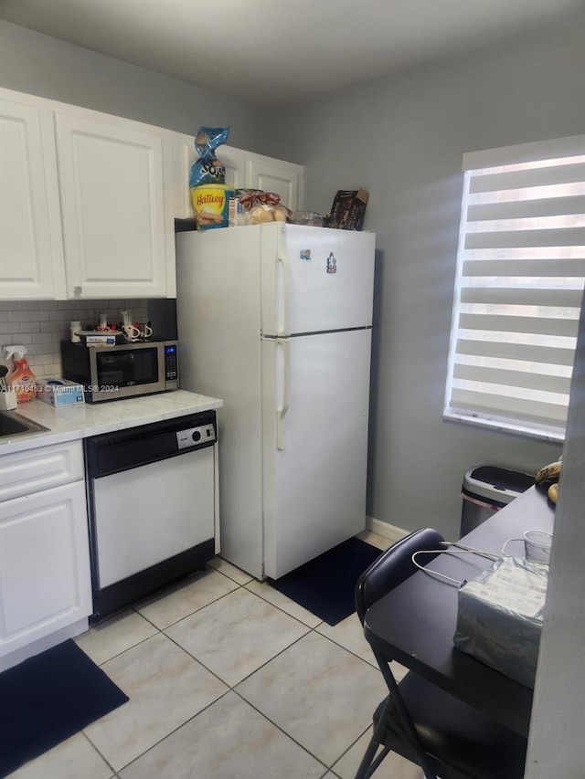 kitchen with white cabinets, decorative backsplash, white appliances, and light tile patterned flooring