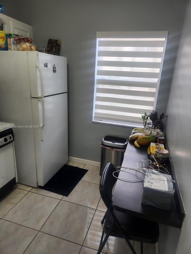 kitchen featuring white cabinets, light tile patterned flooring, and white appliances