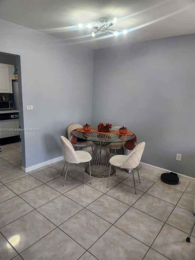 tiled dining space with a chandelier