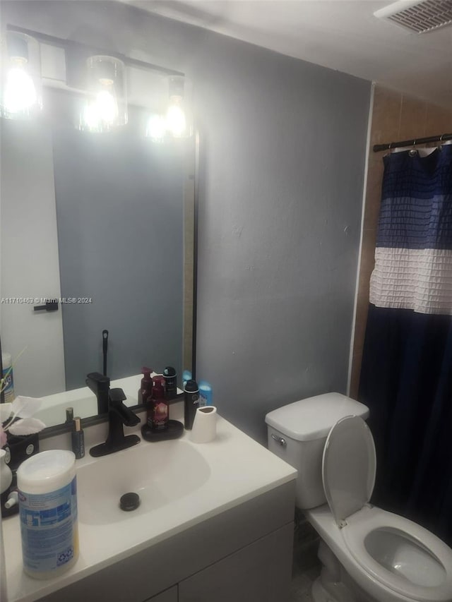 bathroom with toilet, vanity, and a shower with shower curtain