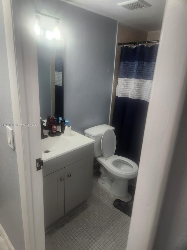 bathroom featuring toilet, vanity, and tile patterned floors