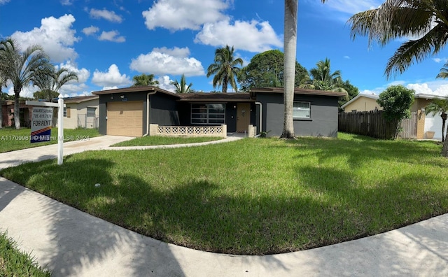 ranch-style house with a garage and a front lawn