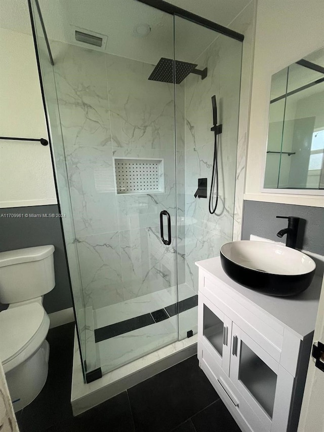 bathroom featuring walk in shower, tile patterned flooring, vanity, and toilet