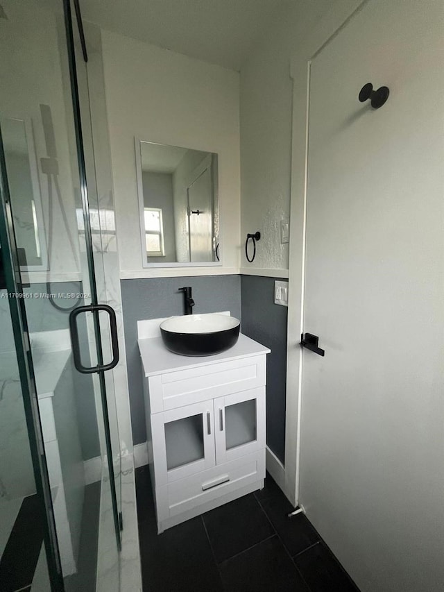 bathroom with tile patterned flooring, vanity, and walk in shower