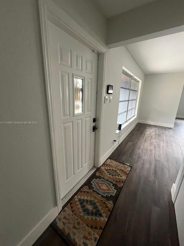 foyer with dark hardwood / wood-style floors and vaulted ceiling