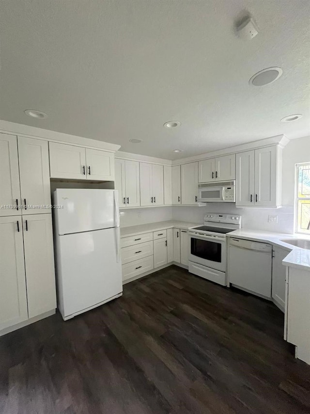 kitchen with white appliances, white cabinetry, dark wood-type flooring, and sink