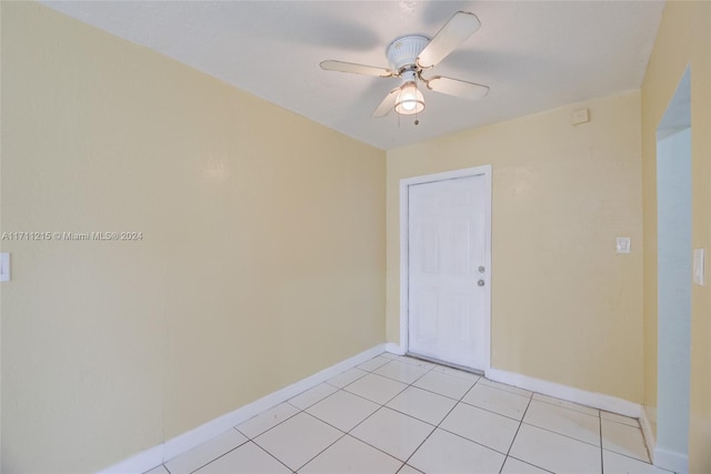 spare room with ceiling fan and light tile patterned flooring