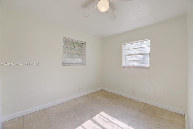 spare room with ceiling fan and light tile patterned floors