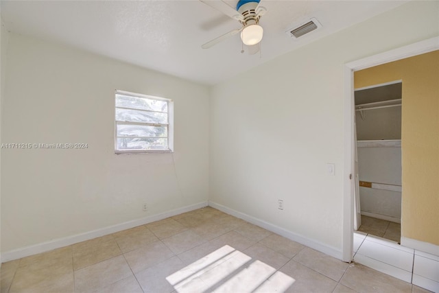 unfurnished bedroom with ceiling fan, a closet, and light tile patterned floors