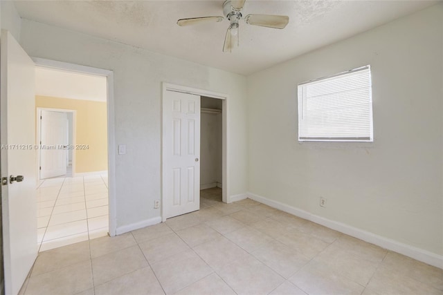 unfurnished bedroom with ceiling fan, a closet, and light tile patterned floors