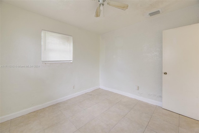 tiled spare room featuring ceiling fan