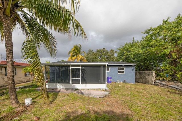 back of house with a sunroom and a yard