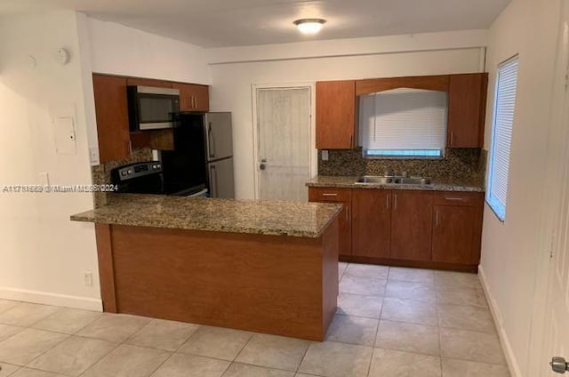 kitchen with electric range, sink, tasteful backsplash, kitchen peninsula, and fridge