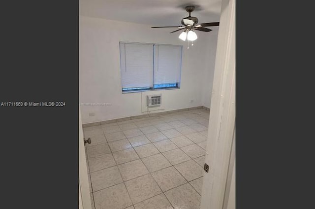 tiled empty room with a wall mounted air conditioner and ceiling fan