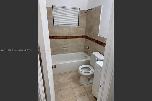 full bathroom with tile patterned flooring, tiled shower / bath combo, toilet, and vanity