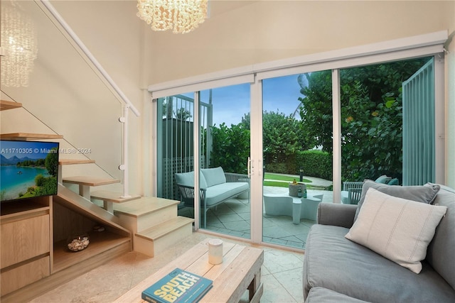 doorway to outside featuring a towering ceiling and a notable chandelier