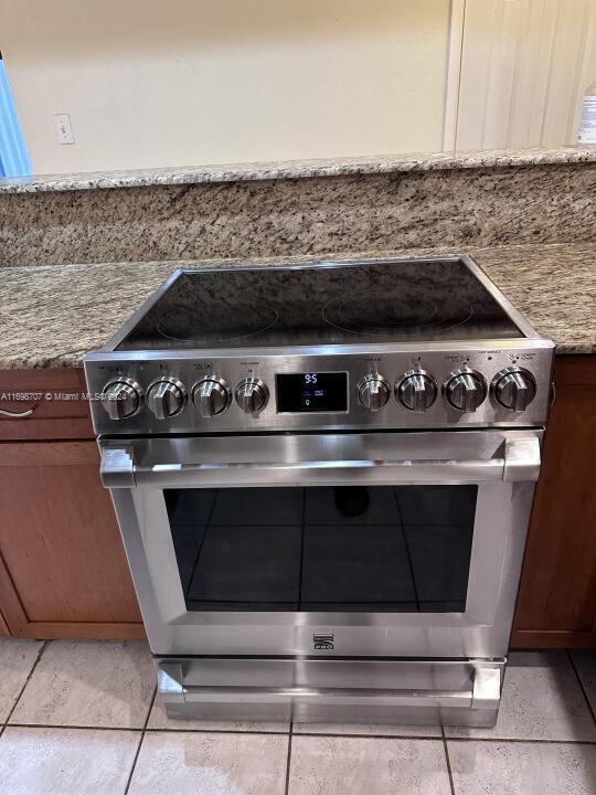 details featuring stainless steel stove and light stone counters