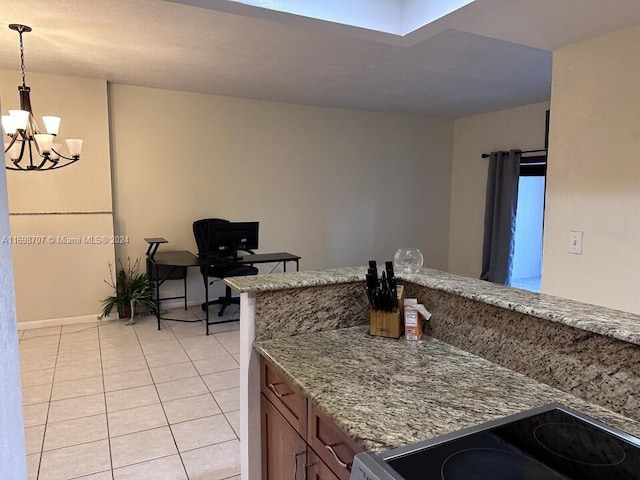 kitchen featuring stainless steel stove, light tile patterned floors, decorative light fixtures, light stone counters, and a chandelier