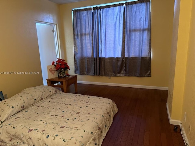 bedroom with dark wood-type flooring