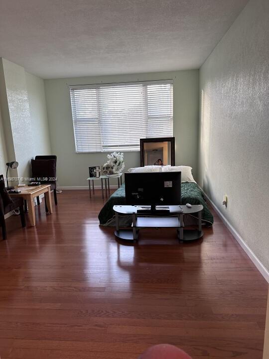 living room with a textured ceiling and dark hardwood / wood-style floors