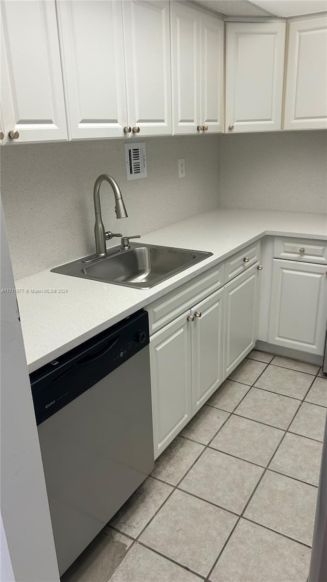 kitchen featuring dishwasher, white cabinetry, sink, and light tile patterned floors