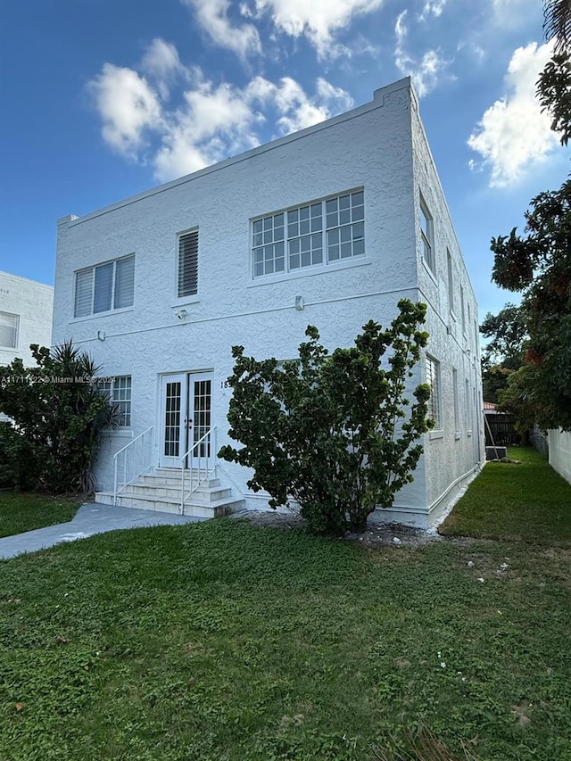 rear view of house with french doors and a yard