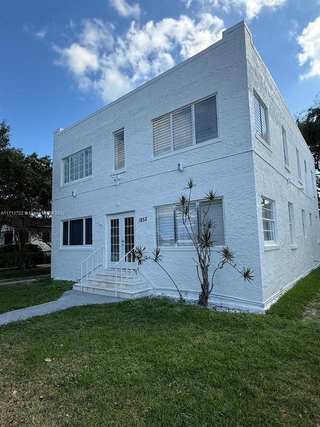 back of property with french doors and a yard