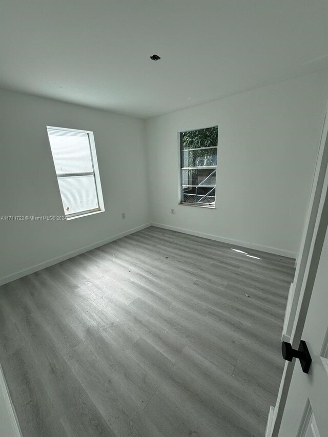 unfurnished room featuring plenty of natural light and light hardwood / wood-style floors