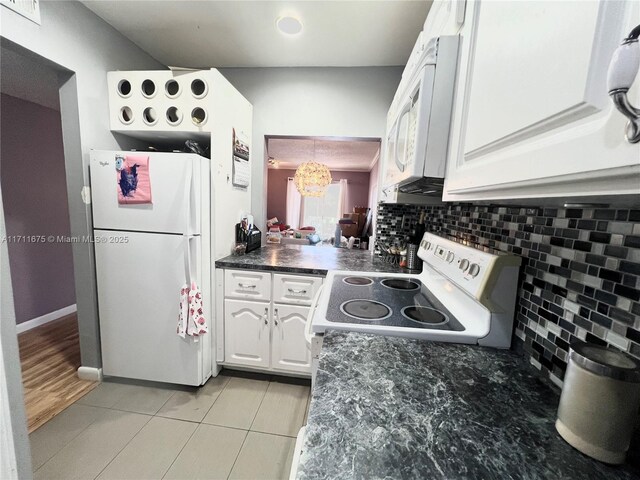 kitchen featuring backsplash, white cabinetry, light tile patterned floors, and white appliances