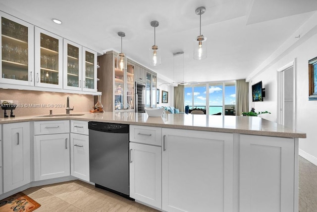 kitchen with stainless steel dishwasher, decorative light fixtures, white cabinetry, and sink