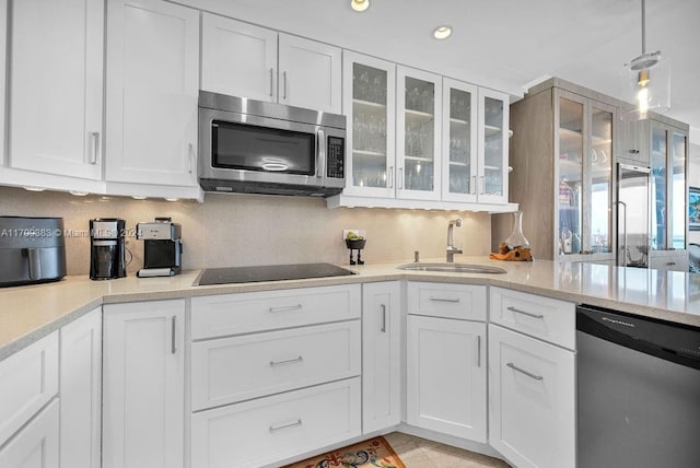 kitchen with appliances with stainless steel finishes, white cabinetry, and sink