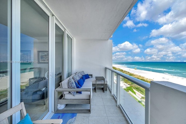 balcony with a water view and a view of the beach