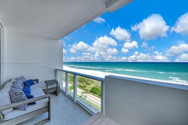 balcony featuring a view of the beach, an outdoor hangout area, and a water view