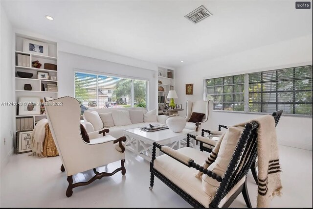 living room featuring built in features and concrete floors