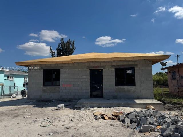 back of property with concrete block siding and fence