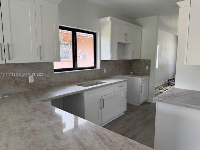 kitchen featuring a sink, white cabinetry, and tasteful backsplash