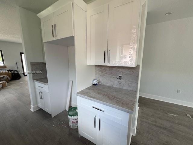 kitchen with dark wood-type flooring, decorative backsplash, and white cabinets