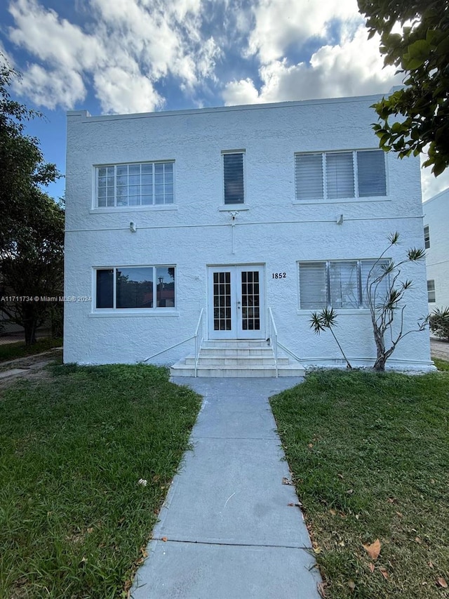 view of front of property featuring a front yard and french doors