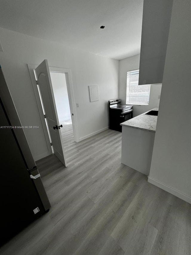 kitchen with electric stove and light hardwood / wood-style flooring