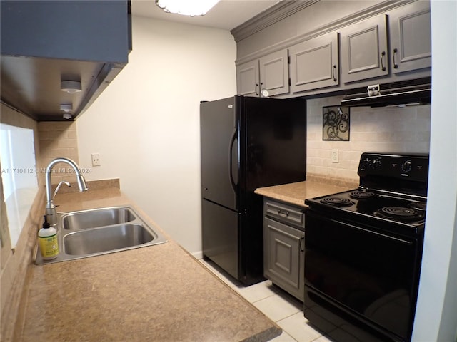 kitchen with backsplash, sink, light tile patterned floors, and black appliances