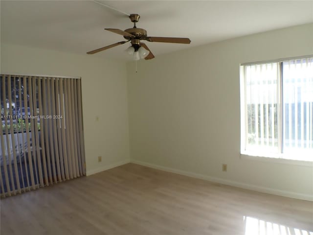 spare room featuring ceiling fan, a healthy amount of sunlight, and light wood-type flooring