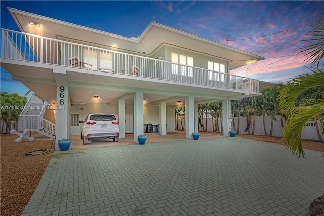 back house at dusk featuring a carport