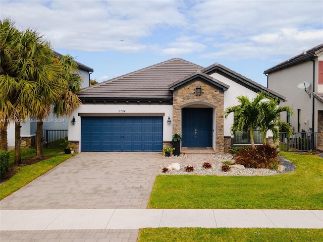 view of front of home with a front yard and a garage